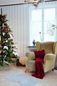 Comfortable wing-back chair next to Christmas tree in vintage-style interior