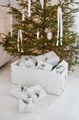 Weißer Spankorb mit Geschenken unterm Weihnachtsbaum