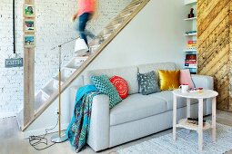 Restaurierte Holztreppe in Wohnraum mit Couch und Upcycling-Schiebetür