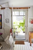 Geöffnete Vintage Hintertür und Blick auf Terrasse mit Grünpflanzen