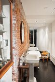Renoviertes Bad mit rustikaler Ziegelwand und nostalgischen Standwaschbecken