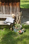 Mit Blumen dekorierte Zinkwanne und Eimer vor einer Holzhütte