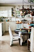 Dining table and chairs with rustic linen loose covers in country-house kitchen