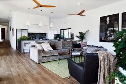 Open living area with upholstered sofa and ceiling fan