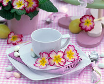 Tasse mit Blüten von Primula (Frühlingsprimel) dekoriert