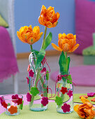 Bottles of felt blossom stuck as small vases