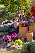 Mother and daughter planting terracotta tubs