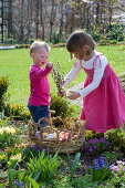 Kinder mit Osternest im Garten