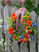 Small wreath of edible flowers, herbs and radishes