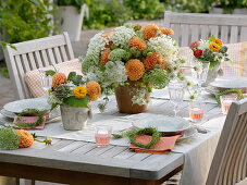 Orange - weiße Tischdeko mit Dahlien