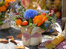 Thanksgiving arrangement stuck in yoghurt pail with corn leaves