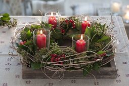 Unusual Advent wreath with ivy, holly berries and Chinese reed