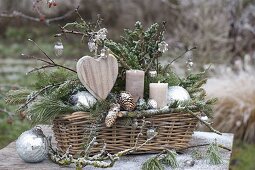 Weihnachtsgesteck in Korbkasten mit Zweigen von Juniperus (Wacholder)