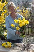 Woman ties a bouquet of narcissus
