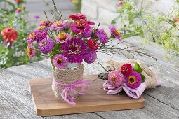 Small zinnia (zinnia) and grasses bouquets in tin can