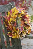 Yellow and red autumn leaves wreath hanged on bench