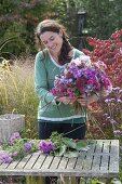 Woman binding autumn bouquet with perennials and grasses