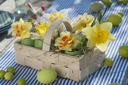 Easter table decoration with narcissus on the terrace