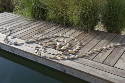 Spiral of pebbles laid on boardwalk at the swimming pond