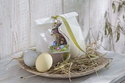 Flat wooden bowl with hay as Easter basket