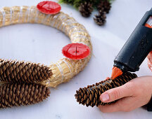 Straw blank as Advent wreath with cones glued on - with hot glue gun