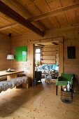 Green retro armchair, wooden table and sheepskin rugs on wooden bench in dacha
