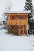Holzhäuschen im Alpenstil im verschneiten Garten
