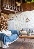 Lounge area on terrace with firewood stacked against wall