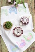 Hand-made table runner with pattern of hens, potted plan and tea set