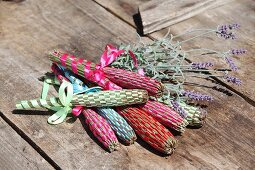 Hand-made lavender wands and lavender on wooden surface