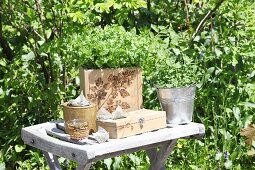 Kitchen herbs in wooden crate with pokerwork motif on garden table