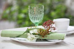Gerolltes Tischset mit Serviettenring aus Blumen