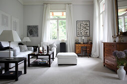 White sofa set, dark coffee tables and antique chest of drawers in lounge