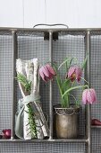 Snake's head fritillaries and linen napkins arranged in upright metal cutlery drawers