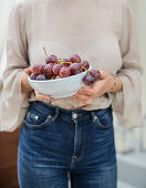 Frau hält Schale mit Weintrauben