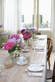 Gedeckter Tisch mit mehreren Hortensiensträußen