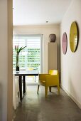 View into dining area with yellow designer chair