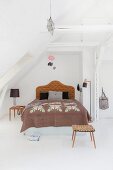 Double bed with headboard in renovated attic apartment