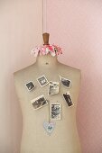Vintage photos stuck to tailor's dummy with drawing pins