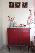 Vintage chest of drawers decorate with candles and branches of red berries