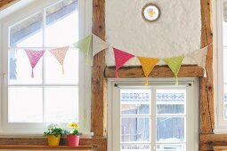 Crocheted bunting hung on half-timbered wall with lattice windows
