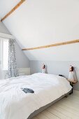 Schlichtes Schlafzimmer unter dem Dach in Weiß und hellem Grau