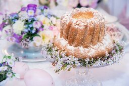 Festively decorated bundt cake on cake stand and centrepiece on Easter table