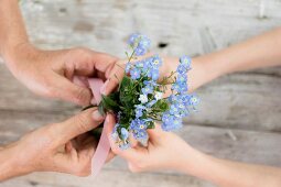Hands holding posy of forget-me-nots