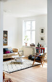 Armchair, coffee table and sofa in bright living room of period building