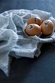 Ostereier mit Tiermotiven beklebt auf Zinnteller und Stoff