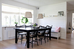 Black dining set with spoke-back chairs and white kitchen bench