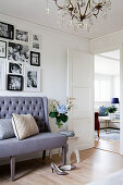 Grey sofa below gallery of family photos on wall