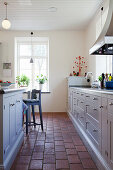 Terracotta floor tiles in bright country-house kitchen