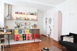 Küchenzeile und buntem Vorhang, Klassikerhocker und Retroschrank in offenem Wohnbereich